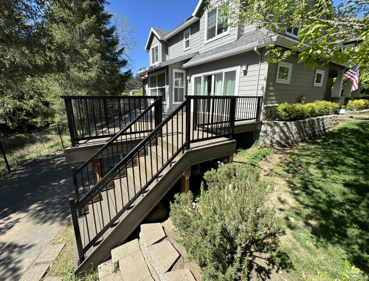 Completed multi-level composite deck with black metal railing built by Big Works