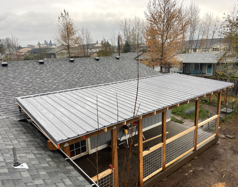 Aerial view of a metal-roofed patio cover on cedar posts with hog-wire railing panels.