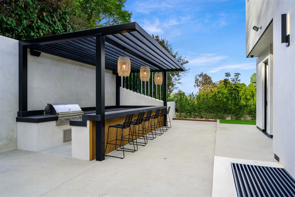 Scenic outdoor patio with a pergola surrounded by trees